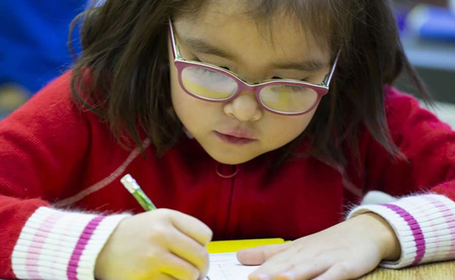student writing at a desk