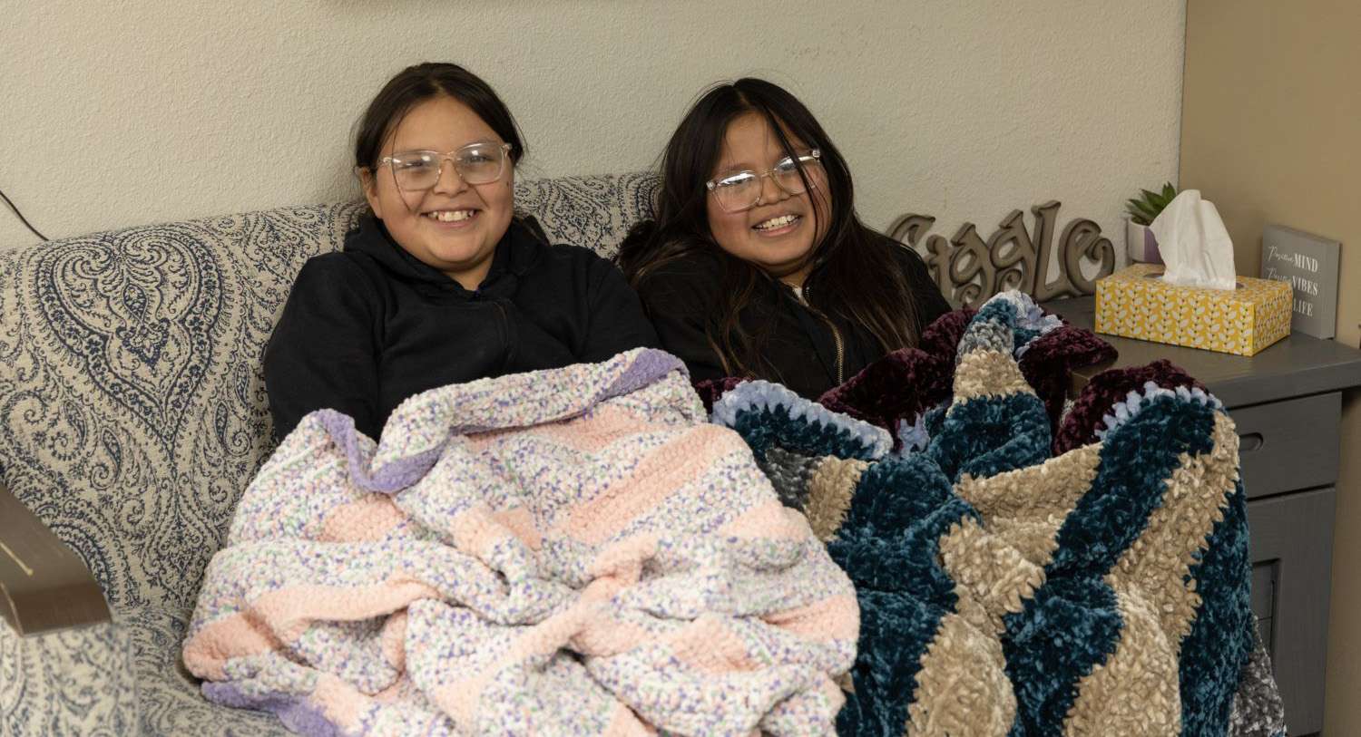 Two Students on couch with blankets