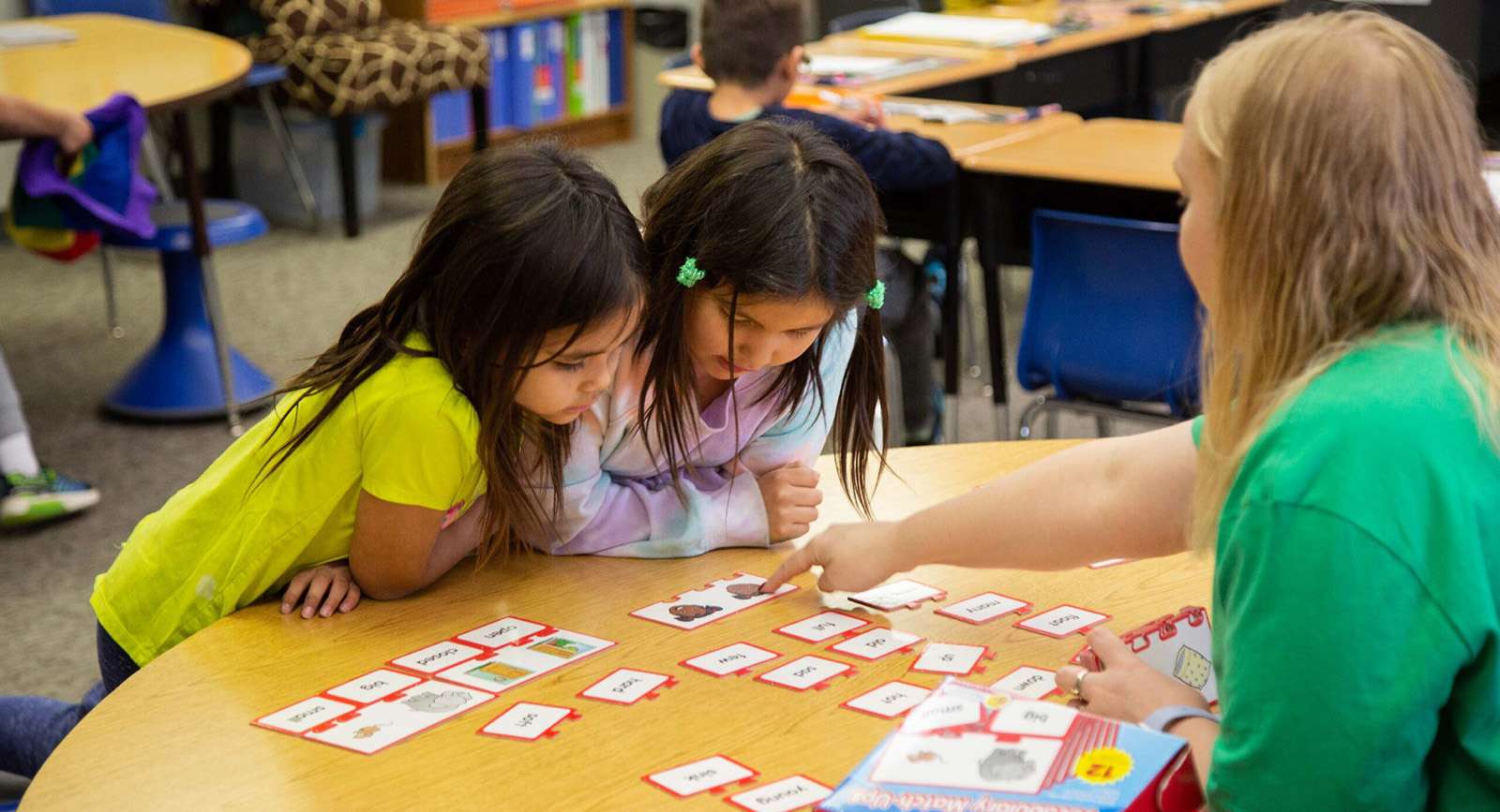 students looking at letter tiles with teacher