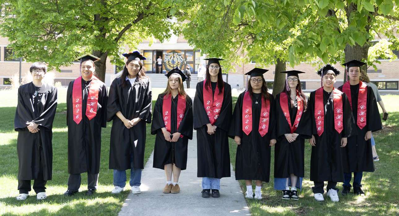 High School Student Graduates Standing in Cap and Gown