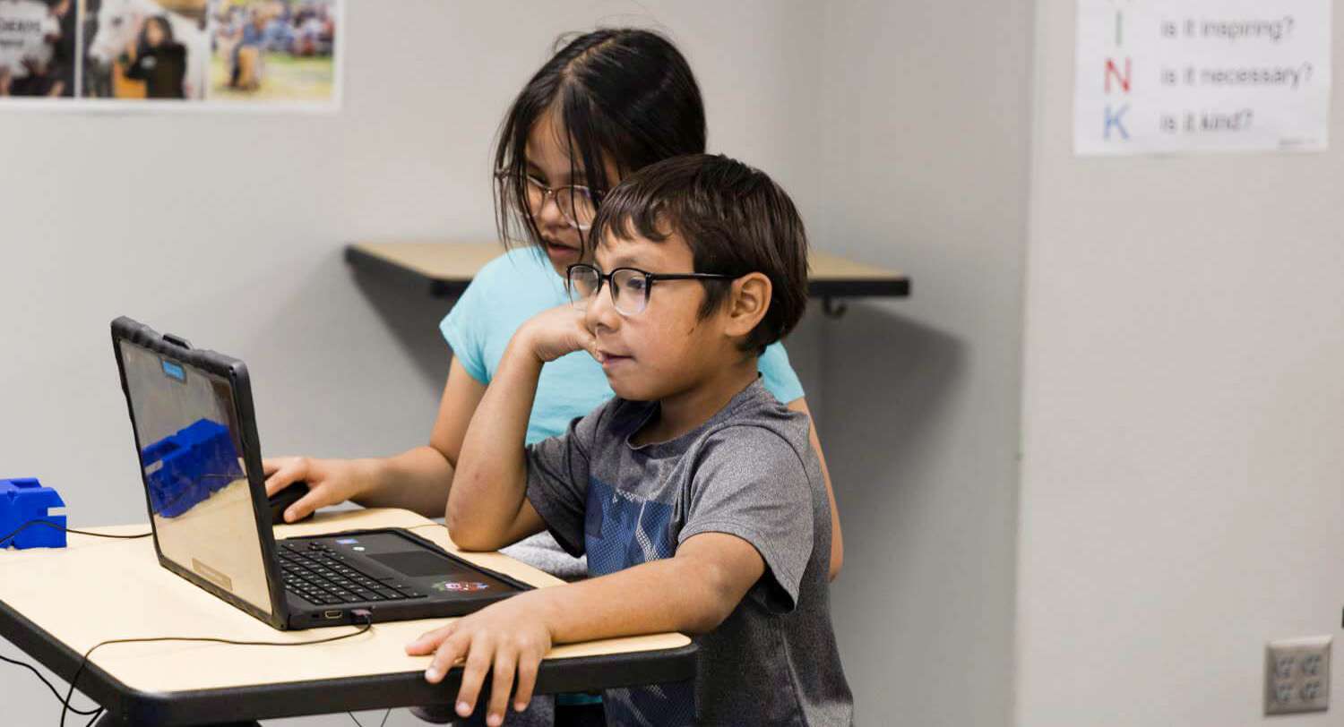 Two students looking at a laptop