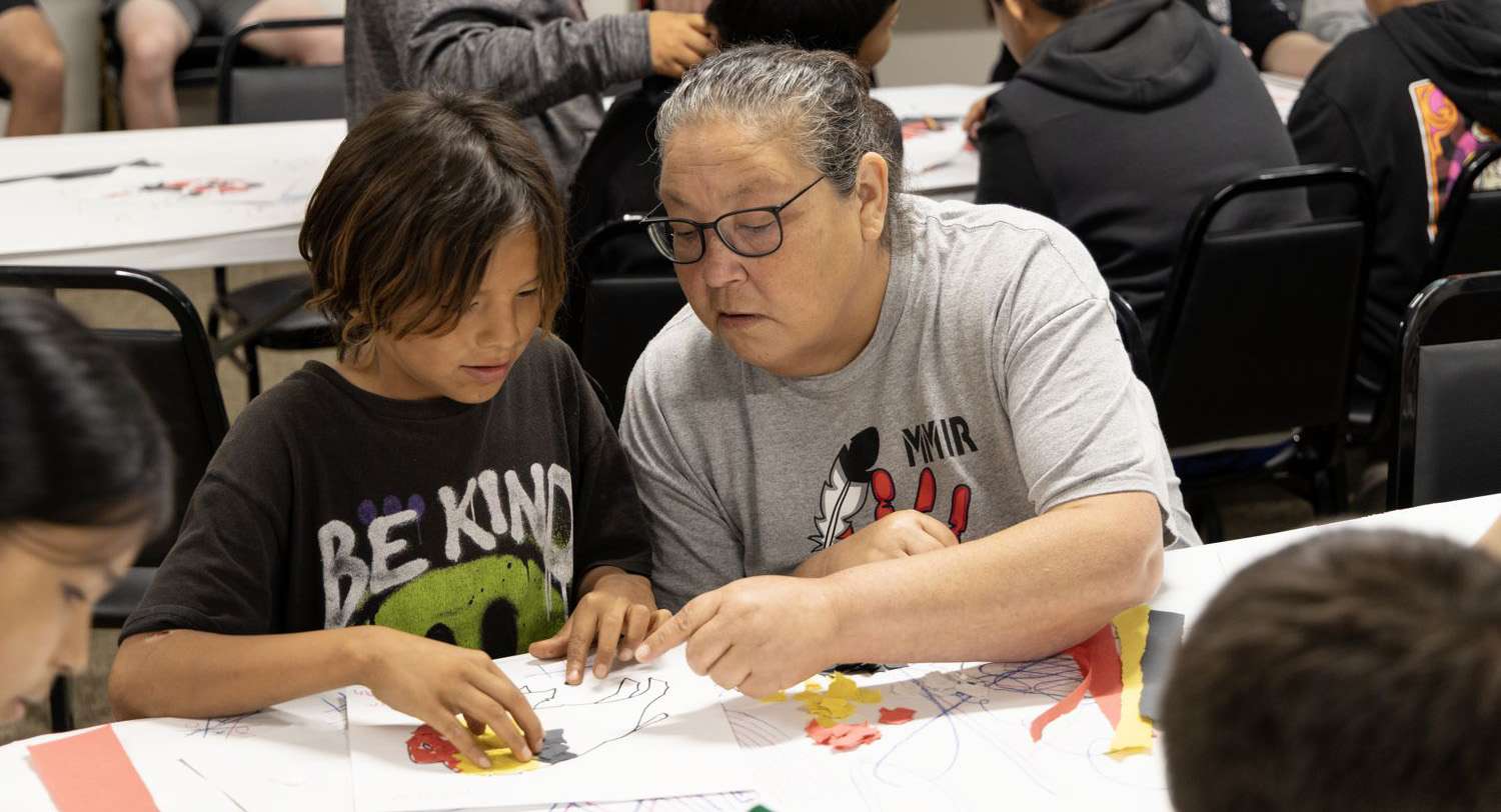 strengths-based-approach Teacher helping student with worksheet